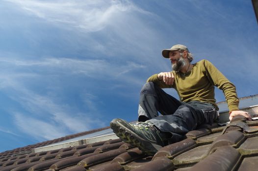 Roofer resting on top of a roof