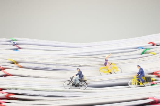 Postmen and woman is cycling on pile overload paperwork of report and receipt with colorful paperclip with white background.
