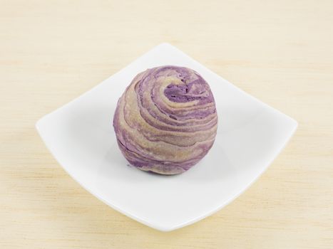 The Taiwanese violet crystal taro cake on the small white square dish.