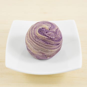 The Taiwanese violet crystal taro cake on the small white square dish.