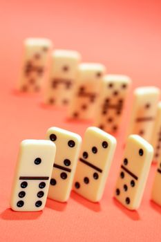 White dominoes standing in a row on red background