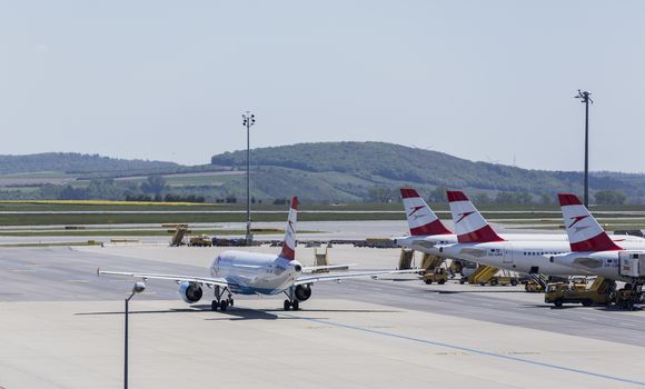 VIENNA, AUSTRIA – APRIL 30th 2016: Plane leaving terminal area on a busy Saturday at Vienna International Airport.