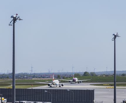 VIENNA, AUSTRIA – APRIL 30th 2016: Planes lined up a busy Saturday ready for take off at Vienna International Airport.