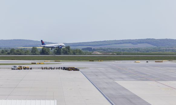 VIENNA, AUSTRIA – APRIL 30th 2016: Plane landing on a busy Saturday at Vienna International Airport.