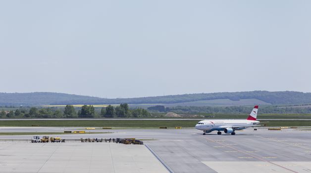 VIENNA, AUSTRIA – APRIL 30th 2016: Plane arriving to terminal area at Vienna International Airport on a busy Saturday.