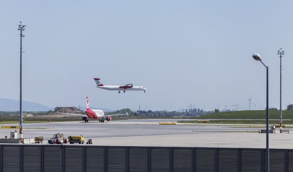 VIENNA, AUSTRIA – APRIL 30th 2016: Plane landing on a busy Saturday at Vienna International Airport.