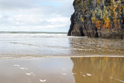 wet sand and cliff reflections on the wild atlantic way in Ballybunion Ireland