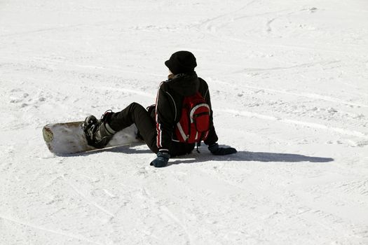 Snowboarder siting on fresh powder snow