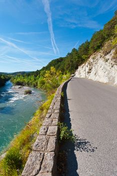 Asphalt Road along the River Bank in French Alps