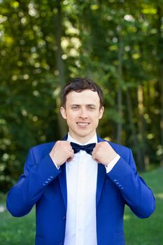 The groom in a stylish dress on the wedding day