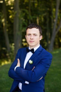 The groom in a stylish dress on the wedding day