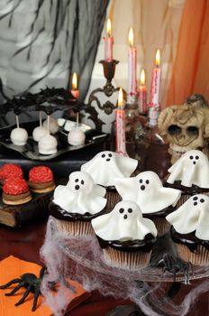 Smorgasbord  сupcakes in chocolate glaze decorated  marzipan ghosts on Halloween 