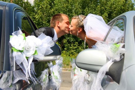 Passionate married couple kissing with car windows