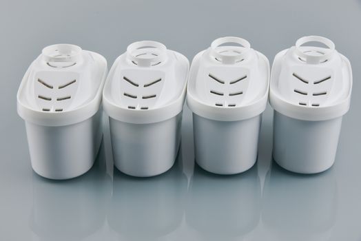 Set of four water filters in row on grey background