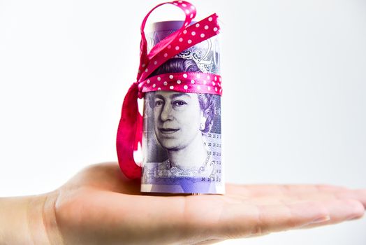 Hand holding bundle of banknotes tied in a bow isolated on white.