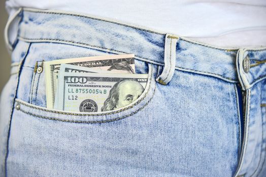 Money sticking out of a blue  jean pocket.