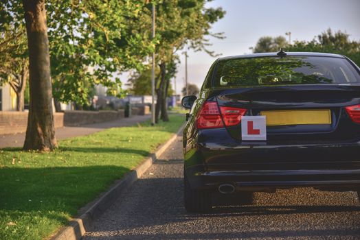 A car with the L plates on ready for a new driver to use.