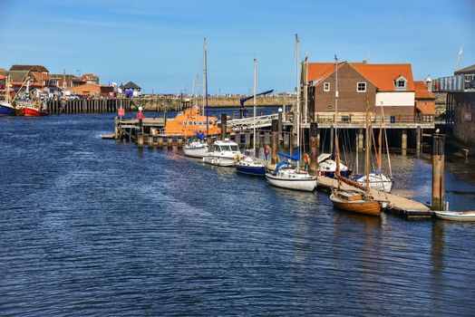 A small yacht and lifeboats at marina in Whitby
