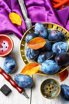 Still life with smoking hookah and the harvest of autumn plums