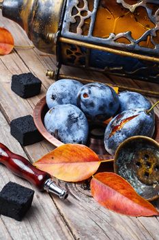 Still life with smoking hookah and the harvest of autumn plums