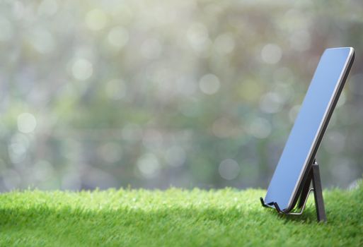 Tablet computer standing on a grass