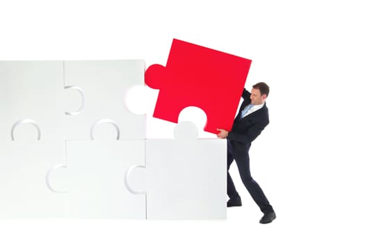 Business man assembling jigsaw puzzle isolated on white background