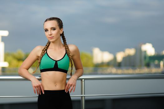 Concept: healthy lifestyle, sport. Attractive happy girl fitness trainer do outdoor workout at modern downtown urban area during sunset.