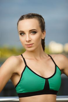 Concept: healthy lifestyle, sport. Attractive happy girl fitness trainer do outdoor workout at modern downtown urban area during sunset.