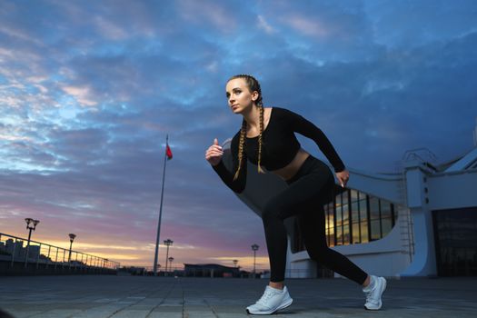 Concept: healthy lifestyle, sport. Attractive happy girl fitness trainer run outdoor workout at modern downtown urban area during sunset.