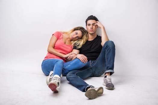 Young couple in love, cuddling, embracing and kissing, studio shot on white background