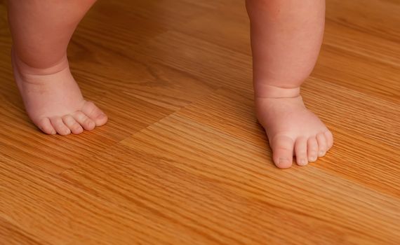 Young girl walking on a hard wood floor for her first time