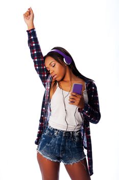 Beautiful teenager girl listening, dancing and jamming to music on mobile phone wearing purple headphones, on white.