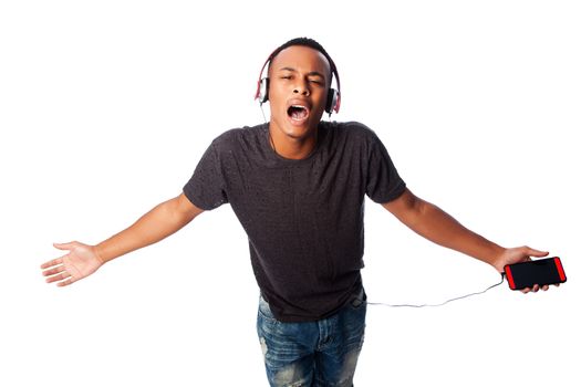 Handsome African teenager happily singing along while listening to music, on white.