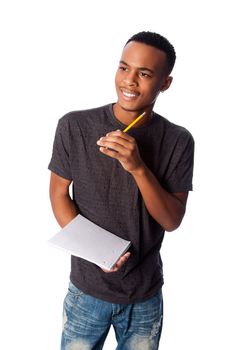 Handsome happy student standing thinking with pencil and notepad coming up with ideas, on white.