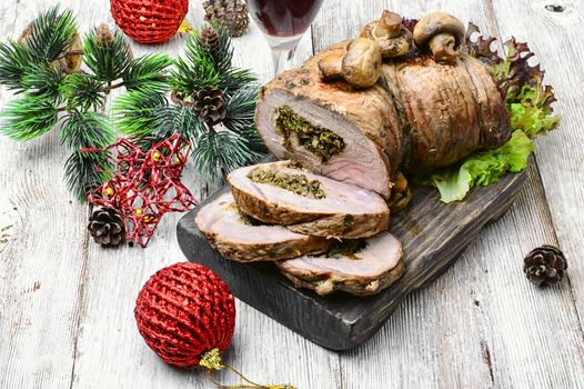 Dish of roulade of veal stuffed with mushrooms and spices and Christmas decorations