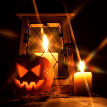Halloween pumpkin and lantern with candle on black background