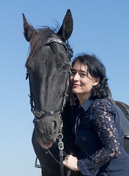  girl riding and a black stallion in a field