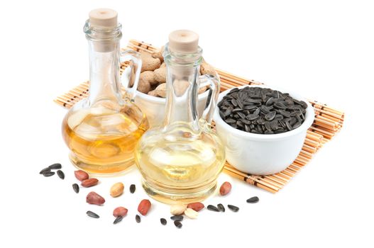 Sunflower seeds, peanuts and bottle of oil isolated on a white background