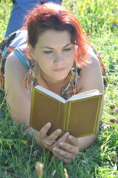 Woman in a meadow reading a book