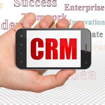 Business concept: Hand Holding Smartphone with  red text CRM on display,  Tag Cloud background, 3D rendering