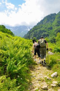 few hikers trekking in alps, Switzerland, with mountains in the background