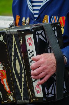 ST.PETERSBURG, RUSSIA - MAY 9, 2014: A very pleasent veteran plays accordion on the 69-th anniversary of the victory in the World War II on May 9, 2013, St.Petersburg, Russia
