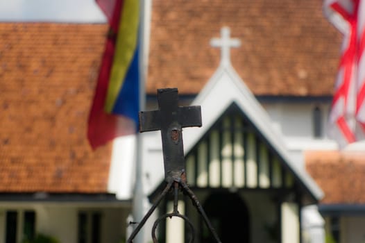 a close up of a two cross on a church in Kuala Lumpur, Malaysia with part of flags