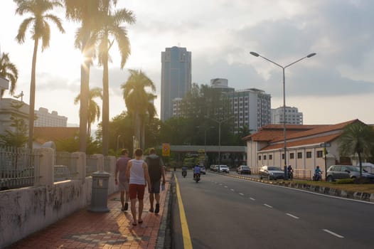 tourist at a city street in Penang, Georg Town, at dusk with light trails and traffic sign, Malaysia.