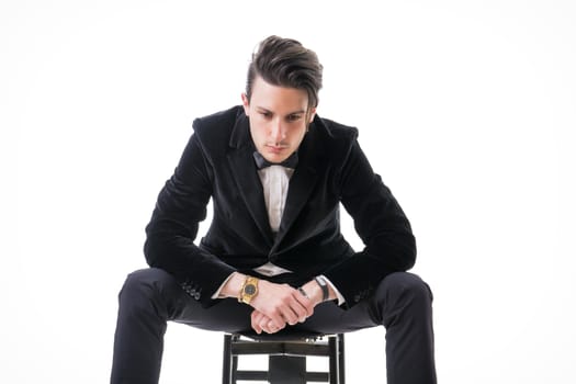 Young businessman confidently posing and looking to a side, wearing suit isolated in white background