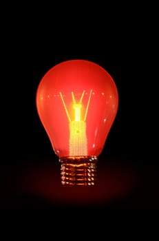 Glowing electric bulb on dark background