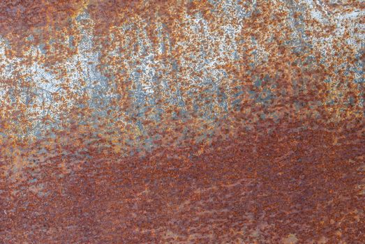 rusty iron surface covered with old chipped paint, which has long been influenced by different climatic conditions