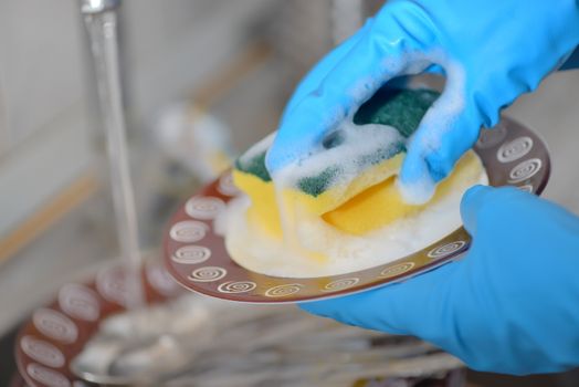 Woman hands washing dishes