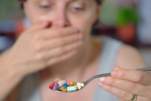 unwanted take pills  woman holding spoon with  pills