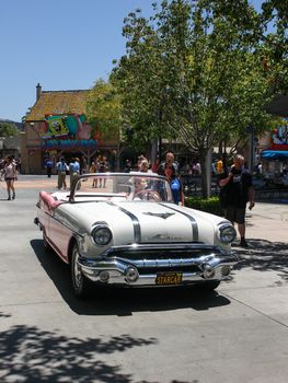 Los Angeles, CA, United States - 15 June 2010. Model in an image of Marilyn Monroe drives through the streets of Universal Studios in Los Angeles Hollywood . Beige Pontiac in retro style perfectly with her dress, hair and glasses.